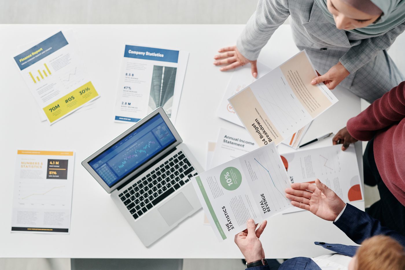 A business discussion using operating documents, analysis charts and a computer