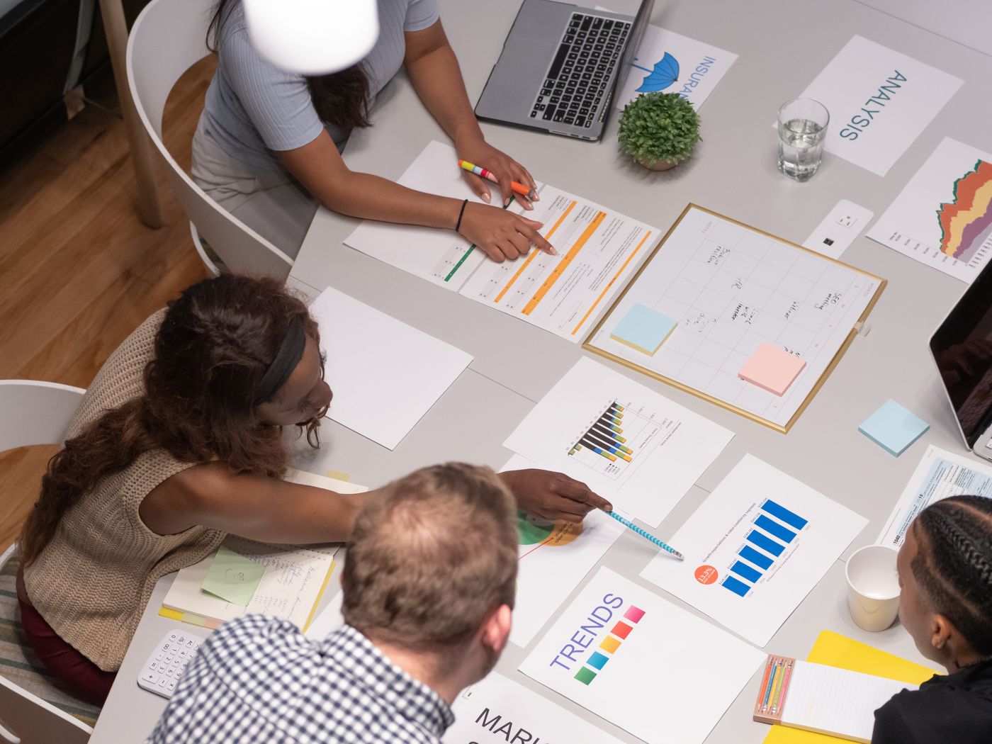 An office discussion around work plans, analysis charts and task schedules