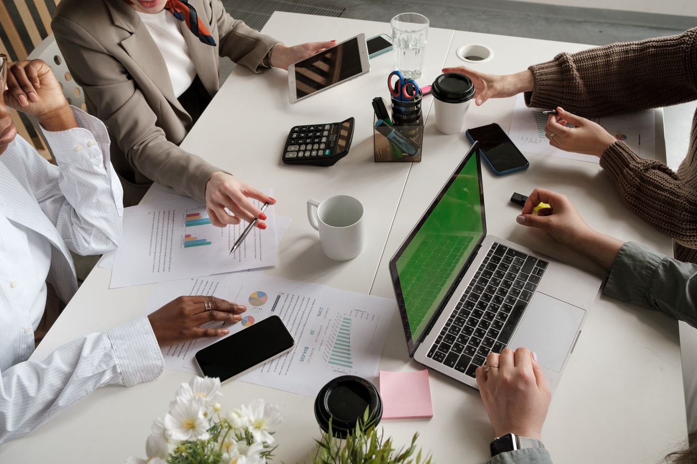 A meeting table with business documents and analysis charts